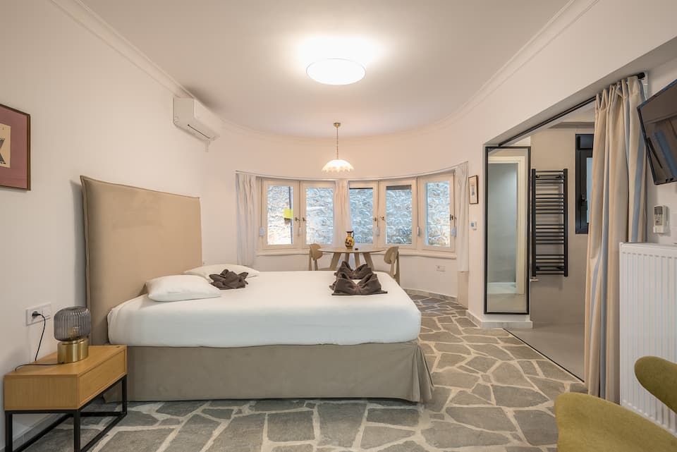 The main room: bed, bay windows, mirror.