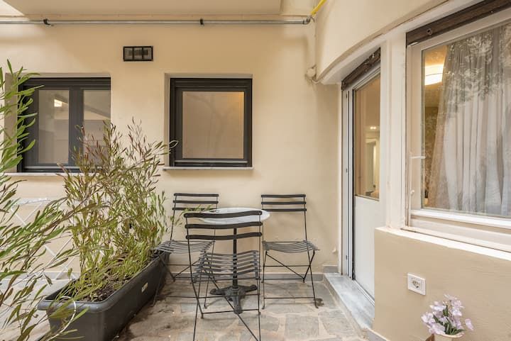 Breakfast outside — planters, gravel, black steel windows.